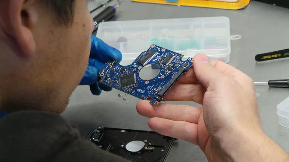 Technicien Mac France contrôlant une carte électronique