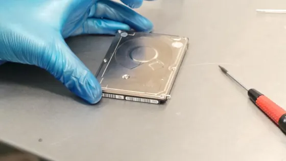 Disque dur de portable manipulé avec des gants